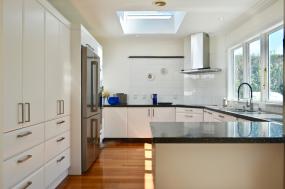 Large white kitchen with a dark acrylic benchtop