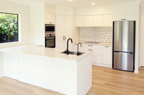 Modern white kitchen with feature black handles and taps