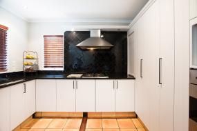 White Kitchen with Feature Black Countertops and Splashback