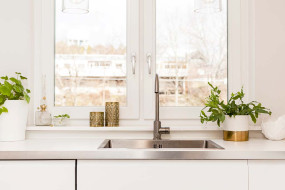 Crisp-white kitchen complete with steel tap and sink