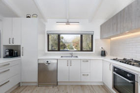White kitchen, silver handles, with white brick tiled backsplash